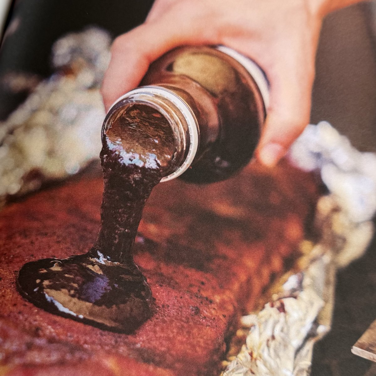 Barbecue sauce being poured over St Louis cut pork ribs